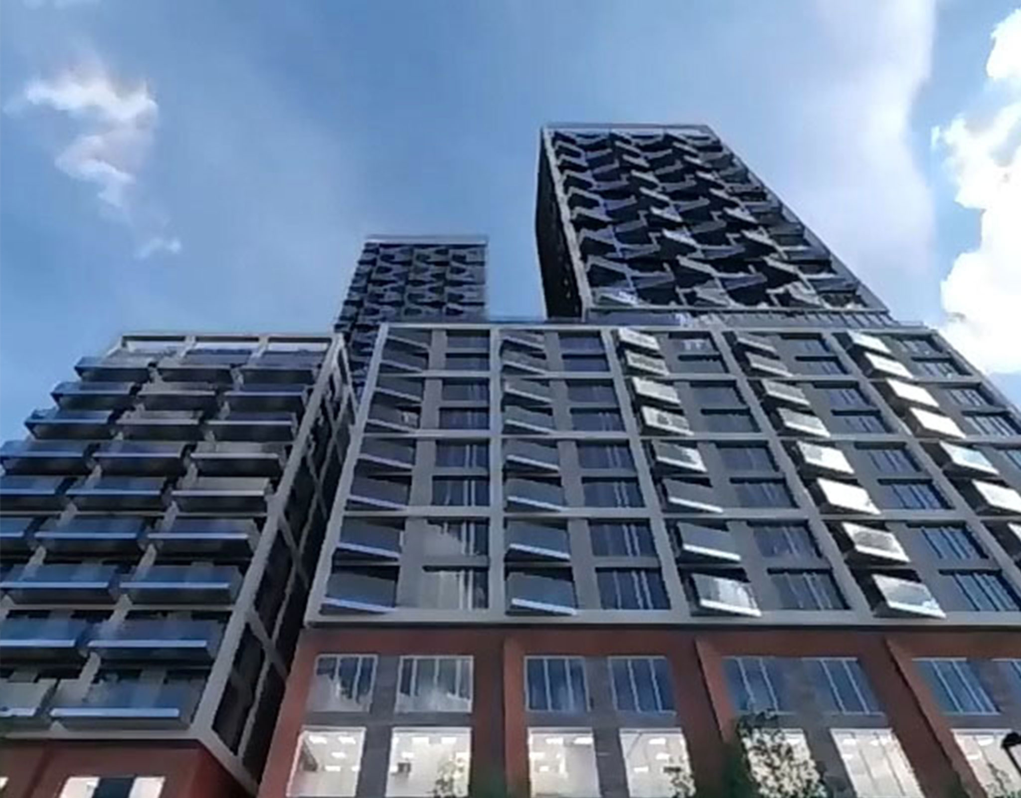 Faceted dark high-rise facade photographed looking up from street level